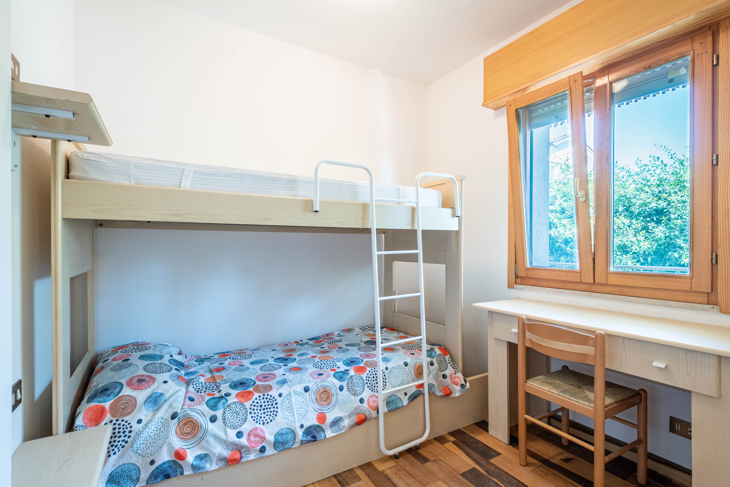 Zona notte aggiuntiva con letto a castello e scrivania nel bilocale a Lignano Sabbiadoro